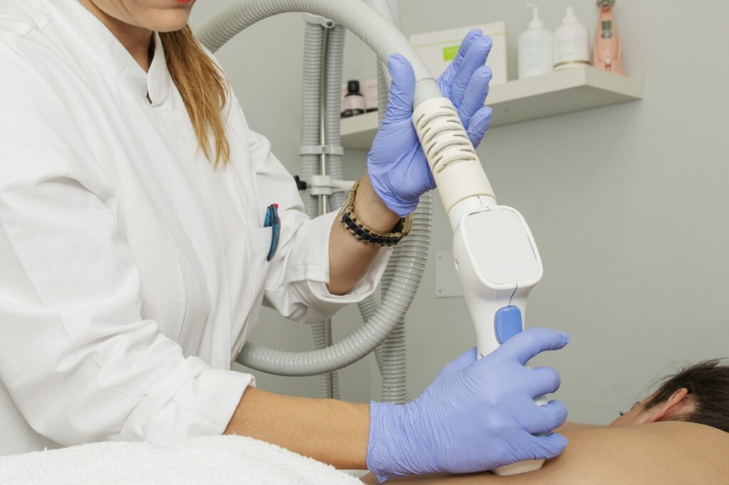 A med spa provider delivers a treatment to a client. As business grows and costs increase, it may be time for them to start updating their med spa prices.